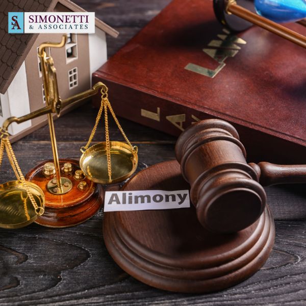 Gavel, scales of justice, law book, and a paper labeled "Alimony" on a desk, with a model house and Simonetti & Associates logo visible—ideal setting for a Huntington Divorce Lawyer handling alimony matters.