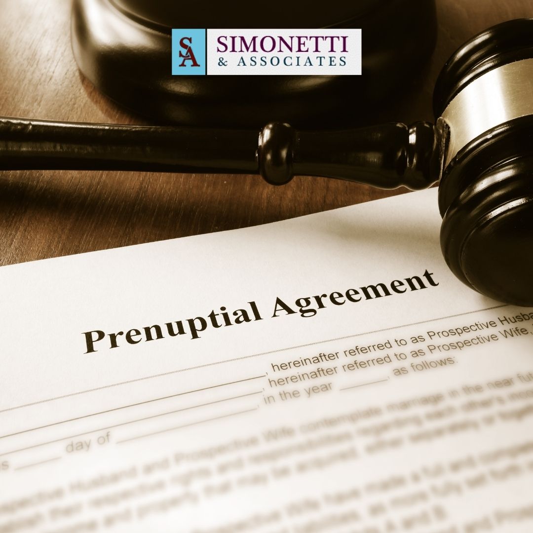 A prenuptial agreement document sits on a table beside a judge's gavel, with a Simonetti & Associates logo in the background, highlighting the expertise of a Hicksville Divorce Lawyer.