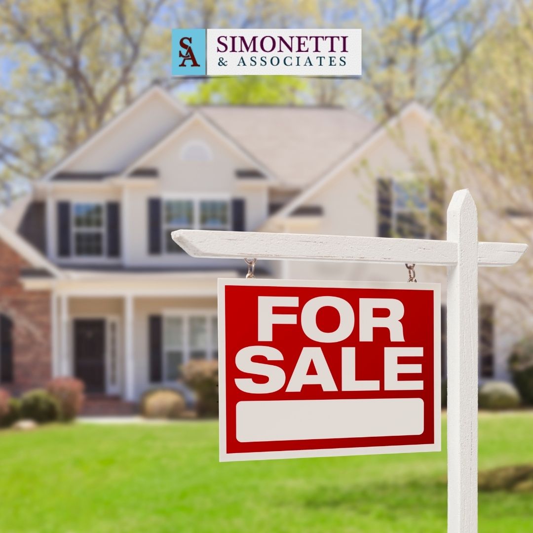 A "For Sale" sign is displayed in front of a two-story suburban house, with a Simonetti & Associates logo at the top, suggesting that those in need of a divorce lawyer in Hicksville may find support during life's transitions.