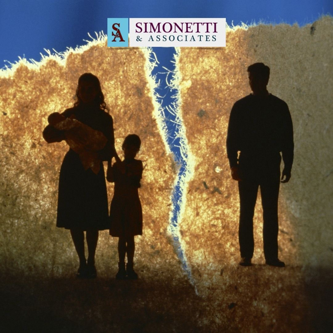 Silhouette of a family separated by a jagged tear in the background, with the Simonetti & Associates logo above—illustrating the guidance of a Suffolk Family Lawyer during challenging times.
