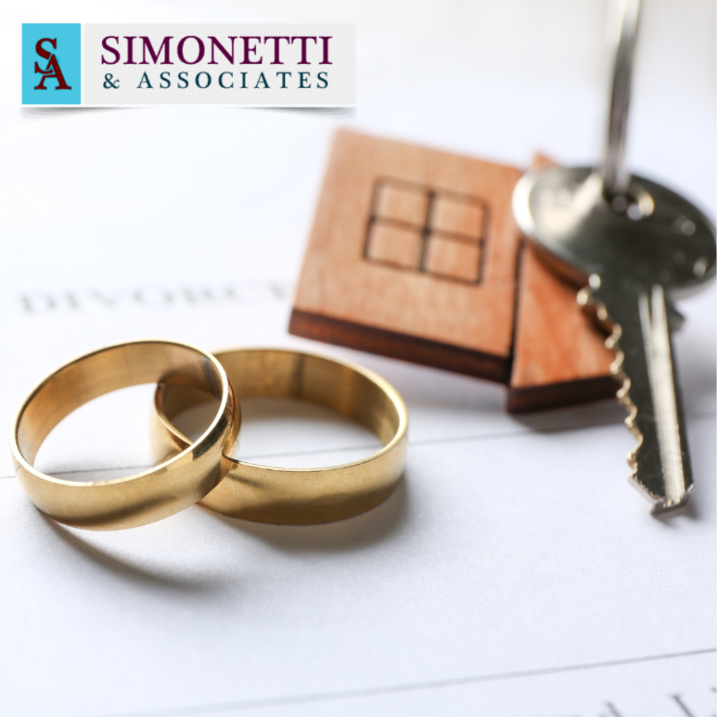 Two gold wedding rings, a house key on a keychain, and divorce papers with the Simonetti & Associates logo in the background.