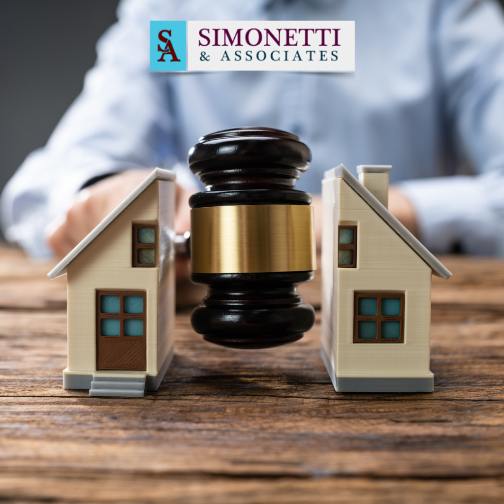 A judge's gavel splits two model houses, symbolizing property division, with the Simonetti & Associates logo in the background.